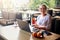 Smiling mixed race woman with cocktail in hand works with laptop. Businesswoman in glasses drinks juice for body