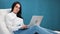 Smiling mixed race woman posing in comfy white armchair with notebook. Shot with RED camera in 4K