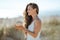 Smiling modern woman on ocean shore holding coconut