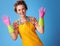 Smiling modern woman showing rubber gloves on blue