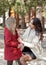 Smiling mom helps little cute daughter fasten her red coat