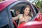 Smiling mom holding coffee cup, driving with her amazed daughter