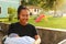 Smiling mom holding newborn baby boy outdoor