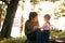 Smiling mom teaches a little girl to count on her fingers sitting on a stump in the forest