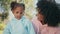 Smiling mother adoring daughter relaxing nature close up. African family in park