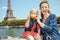 Smiling mother and child travellers making smile with croissant