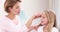 Smiling mother combing hair of daughter