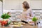 Smiling mother and daughter cooking together in kitchen vegetable salad. Healthy home food, communication parent and child