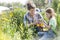 Smiling mother and daughter looking at flowers while gardening at farm