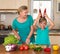 Smiling mother and funny playful daughter cooking together, help children to parents.