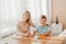 Smiling mother helping adorable son doing schoolwork at home