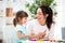 Smiling mother helps a little daughter to sculpt figurines from plasticine. Children`s creativity. Happy family