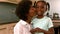 Smiling mother kissing daughter in kitchen