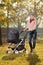 A smiling mother posing with a baby stroller