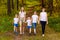 Smiling mothers and children holding hands. Big happy family, two women and three children in white t-shirts