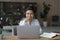 Smiling motivated Indian businesswoman in eyeglasses working on laptop.