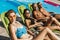 smiling multicultural friends in swimsuits sunbathing on sunbeds