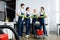 Smiling multiethnic cleaners talking near cart