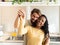 Smiling multiethnic heterosexual couple show the keys to their new house