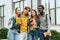 Smiling multiethnic teenagers with books embracing