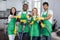 Smiling multiracial team of professional cleaners showing thumbs up to camera
