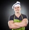 Smiling muscular man cook with arms folded