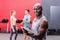 Smiling muscular trainer writing on clipboard