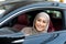 Smiling muslim woman test driving car in urban city