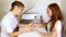 Smiling nail technician examining pretty customers hands