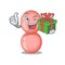 Smiling neisseria gonorrhoeae cartoon character having a green gift box