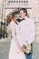 Smiling newlywed couple dancing and hugging near old gothic christian cathedral
