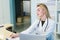 Smiling nurse with laptop scheduling appointment for male patient at reception