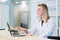 Smiling nurse with laptop scheduling appointment for male patient at reception