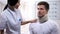 Smiling nurse looking at man in foam cervical collar, medical healthcare, clinic