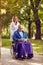 Smiling nurse pushing elderly man in wheelchair while reading bo