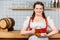 smiling oktoberfest bartender in traditional bavarian dress showing mug of light beer