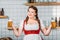 smiling oktoberfest waitress in traditional bavarian dress holding mugs of light beer