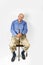 Smiling old man holding a walking stick sits on a chair