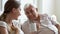 Smiling older father and adult daughter chatting at home