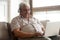 Smiling older man wearing headphones using laptop at home