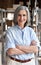 Smiling older woman manager standing in delivery shipping warehouse, portrait.