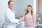 smiling ophthalmologist and patient shaking hands