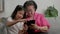 Smiling overjoyed mature grandmother with little granddaughter using tablet on cozy couch. Happy mature granny and small