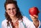 Smiling paediatrician woman giving an apple on blue