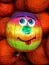 Smiling Painted Pumpkin In A Group Of Pumpkins