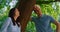 Smiling pair standing on nature closeup . Happy couple relax lean on tree trunk.