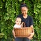 Smiling Papuan mom with baby in wicked basket