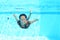 Smiling Papuan woman swimming in pool in brown dress