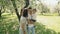 Smiling parents holding up son in summer apple tree park. Happy family concept