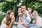 Smiling parents with two kids eating cupcakes on picnic